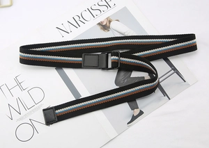 Striped canvas belt with double D-ring buckle laid on fashion magazines for detail