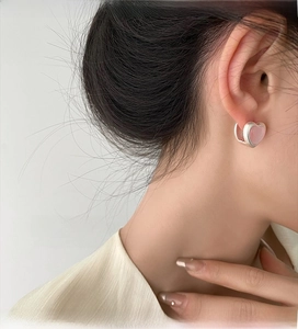 Close-up of pink heart-shaped earrings on model for a sweet and elegant look