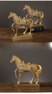 Detail view of golden horse statue with blue gemstone saddle on rectangular base