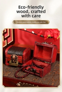 Detail of vintage red wooden jewelry box with antique metal lock and beaded bracelet
