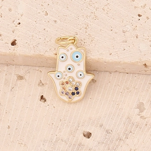 Macro shot of gold Hamsa hand pendant with blue evil eye patterns and colorful crystals