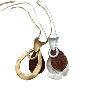 Matte gold and silver teardrop pendants with dark brown woven texture on snake chains