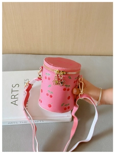 Pink cylinder kid bucket bag with cherry prints and golden flower zipper detail