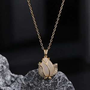 Détail du pendentif tulipe avec pierre d'opale et zircons sur une pierre grise