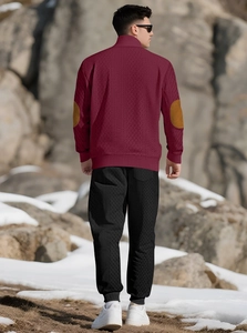 Detail of men's waffle knit sweater in burgundy with brown elbow patches in outdoor snow