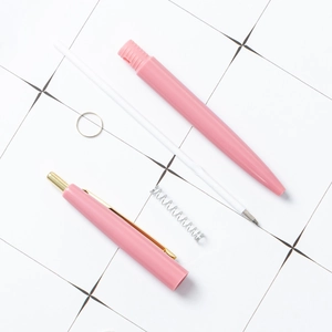 Detailed view of pink retractable ballpoint pen components disassembled on grid background