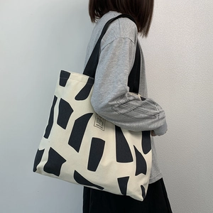 Detailed view of the large canvas tote bag with abstract geometric print and woven handles