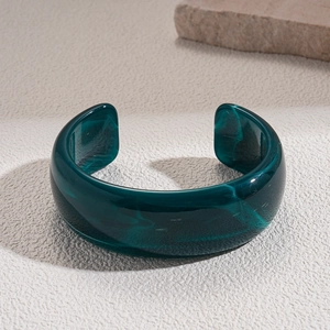 Macro shot of dark green marbled acrylic open bangle with natural resin texture