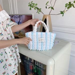 Close-up of blue and white striped seersucker tote bag featuring bubble texture fabric