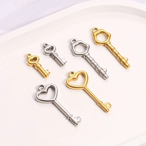 Golden and silver stainless steel key pendants for DIY necklaces on a white tray