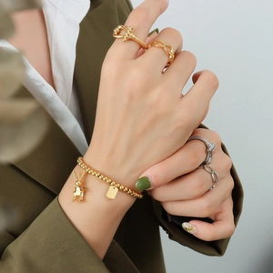 Goldenes Perlenarmband mit Hasenanhänger und mehrlagiges Ringset für Damen in elegantem Gold
