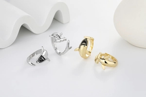 Detail of hammerhead and great white shark open rings in gold and silver finishes