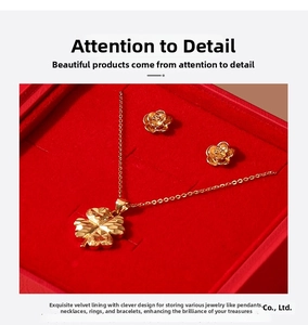 Detailed view of gold clover necklace and rose earrings in a red velvet jewelry gift box