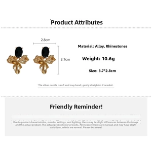 Detail view of gold flower earrings with black oval rhinestones and size measurements