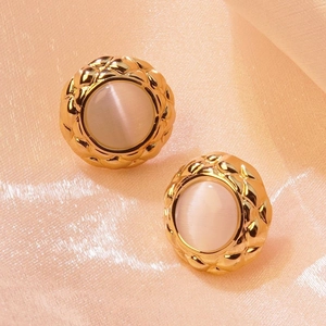 Detailed view of vintage gold stud earrings with diamond pattern and white faux stone