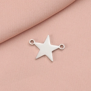 Polished silver stainless steel star pendant connector with double holes on pink fabric