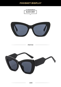 Detail view of black cat-eye sunglasses with thick geometric temples and grey lenses