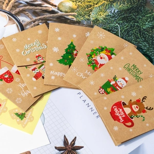 Flat lay of brown kraft paper Christmas cards with colorful reindeer and snowman illustrations