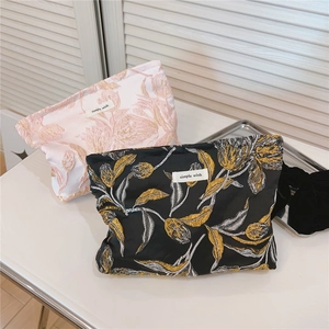 Detailansicht der Tulpen-Jacquard-Stickerei auf Kosmetiktaschen mit goldenen Blumenmustern