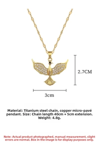Detailed view of flying bird pendant with white rhinestones and gold titanium steel chain