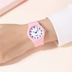 Close-up of pink quartz watch with large numeric dial on a model wrist
