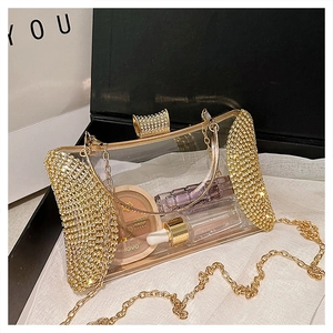 Detail of transparent acrylic evening bag with gold rhinestones and chain strap