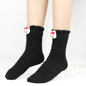 Detailansicht warmer Korallenfleece-Socken in Schwarz mit niedlicher Weihnachtsmann-Puppe