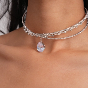 Close-up of elegant double-layered silver choker with a sparkling pear-cut zircon pendant