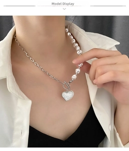 Detail of heart pearl necklace with OT toggle clasp and silver-tone chain on a model