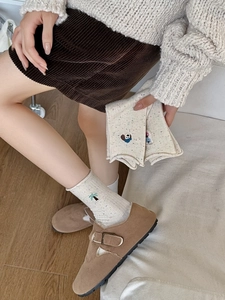 Détail de chaussettes en coton avec broderies de palmier, panda et icônes de dessins animés