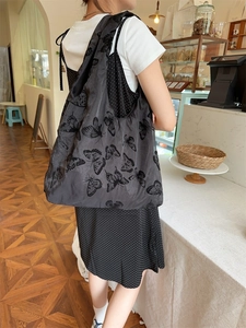 Detail of a large capacity sheer mesh tote bag with black butterfly patterns