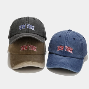 Close-up of vintage washed cotton baseball caps with embroidered New York text