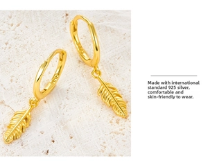 Detailed macro view of S925 sterling silver feather earrings with refined gold plating