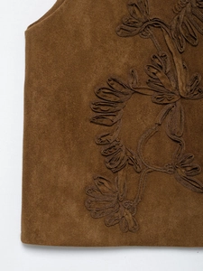 Detailed view of exquisite floral embroidery on brown suede fabric for women