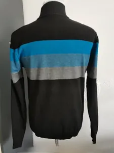 Close-up of slim fit knitted sweater with turtleneck and blue color block stripes