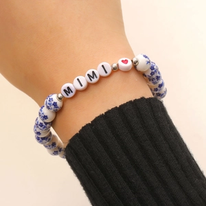 Dettaglio del braccialetto elastico in ceramica con perle floreali blu e ciondoli MIMI