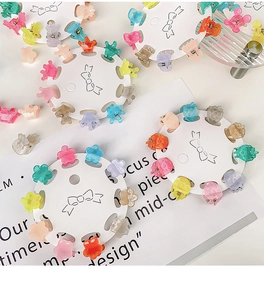 Close-up of mini candy-colored jelly hair clips in star and flower shapes on white card