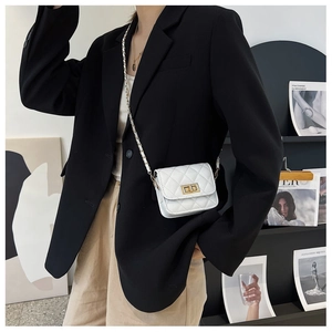 Dettaglio ravvicinato della mini borsa bianca trapuntata con fibbia dorata e catena