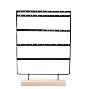 Black metal jewelry organizer with four-tier earring stand and wooden base on white background