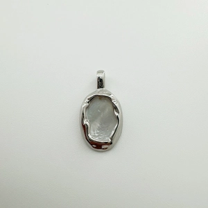 Detail of silver 18K gold-plated pendant with white shell and hammered texture