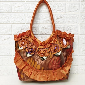 Detail of orange satin tote bag with 3D handmade rose flower and ruffle edges