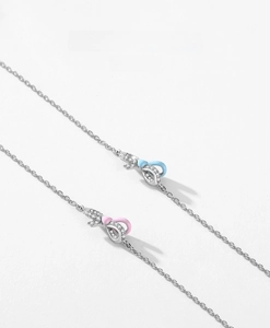 Detailed close-up of S925 silver bow charms with pink and blue enamel inlay