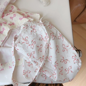 Détail du sac à bandoulière en coton blanc avec motifs nœuds floraux roses et tissu