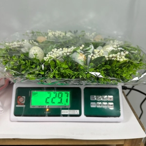 Easter wreath with green leaves and speckled eggs weighing 229.7g on a digital scale