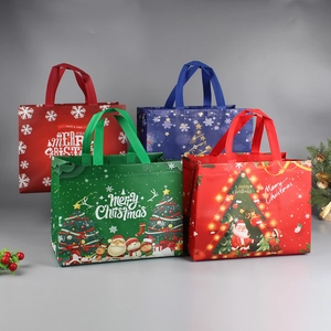Set of four colorful Christmas non-woven gift bags with festive Santa and tree patterns