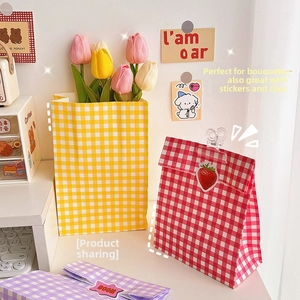 Detailed view of colorful gingham paper gift bags with red, yellow, and purple patterns