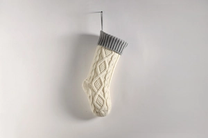 Close-up of cable knit Christmas stocking in cream and grey for holiday home decor