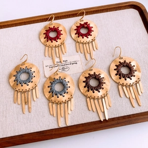 Detailed shot of bohemian hollow round pendant earrings with colorful woven thread tassels
