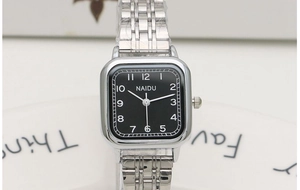 Macro shot of silver square quartz watch with black dial and metal link bracelet