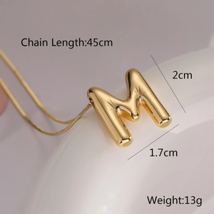 Macro shot of gold balloon letter M pendant necklace with dimensions 2cm and weight 13g